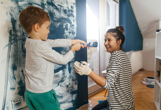 Boy and woman painting room 
Young boy and woman painting room